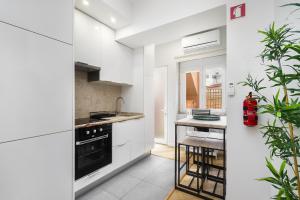 a kitchen with white cabinets and a black oven at Cozy Apt in Lisbon with Terrace by Soulplaces in Lisbon