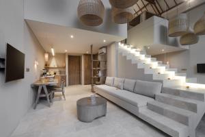 a living room with a couch and a staircase at Loft My Seseh by BaliSuperHost in Canggu