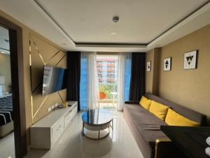 a living room with a couch and a tv at Grand Avenue Super Condo in Pattaya Central