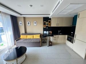 a bedroom with a bed and a desk in a room at Grand Avenue Super Condo in Pattaya Central
