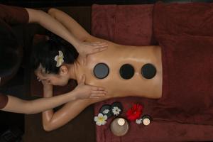 una mujer está acostada en una cama con un cuerpo de persona en Brilliant Nature Suites & Spa, en Hanói