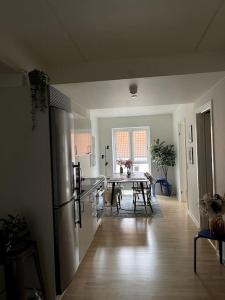 een keuken met een koelkast en een tafel met stoelen bij Moderne lejlighed i hjertet af Odense C in Odense