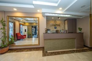 eine Lobby mit einer Rezeption und einem Spiegel in der Unterkunft Raymond Hotel in Istanbul