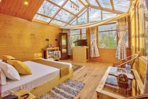 a bedroom with a bed in a glass house at Regal Retreat in Jari