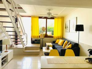 a living room with a blue couch and yellow pillows at Schöner Bungalow mit Terrasse und Pool in Las Palmas de Gran Canaria