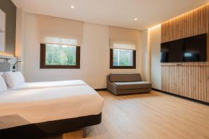 a hotel room with a bed and a chair at Leonardo Hotel San Sebastián in Donostia-San Sebastián