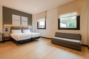 a bedroom with a bed and a chair in it at Leonardo Hotel San Sebastián in Donostia-San Sebastián