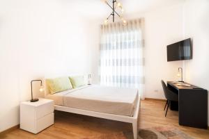 a bedroom with a bed and a desk and a television at L'isola che c'è - Appartamento in Cagliari