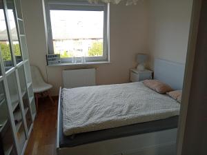a small bedroom with a bed and a window at Mieszkanie w Szczecinie in Szczecin