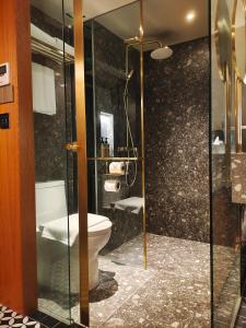 uma casa de banho com um WC e uma cabina de duche em vidro. em Bintang Collectionz Hotel em Kuala Lumpur