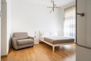 a bedroom with a bed and a chair at L'isola che c'è - Appartamento in Cagliari +56 photos
