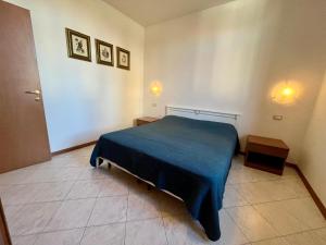 a bedroom with a blue bed and two tables at Posta Vecchia in Grado