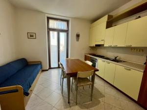 a small kitchen with a table and a blue couch at Posta Vecchia in Grado