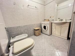 a bathroom with a toilet and a sink and a washing machine at Posta Vecchia in Grado