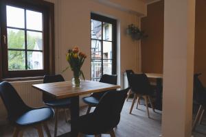 een eetkamer met een tafel en stoelen en een vaas met bloemen bij Altstadt Quartier in Schotten