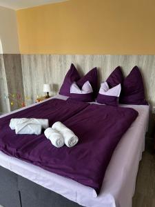 a large purple bed with three white towels on it at Apartment R&eacute;v&eacute;sz in Hark&aacute;ny