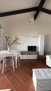 sala de estar con mesa y sofá en Prezioso appartamento con vista mozzafiato - Casa Enrica, en Castelsardo