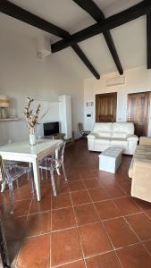 ein Wohnzimmer mit einem Tisch und einem Sofa in der Unterkunft Prezioso appartamento con vista mozzafiato - Casa Enrica in Castelsardo