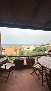 Un balcón con sillas y vistas al océano. en Prezioso appartamento con vista mozzafiato - Casa Enrica, en Castelsardo