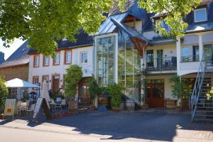 ein großes Gebäude mit einer Glasfassade davor in der Unterkunft Ferienweingut & Gutsrestaurant Becker in Burgen