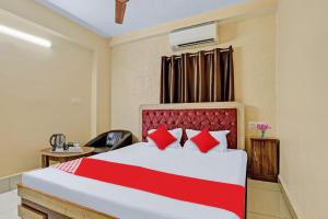 a bedroom with a large bed with red pillows at Flagship Sri Jagarnath Banquet & Hotel in Rānchī
