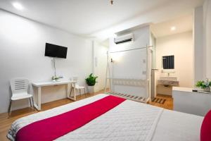 a white bedroom with a large bed and a desk at PHÚ GIA BÙI VIỆN HOTEl in Ho Chi Minh City