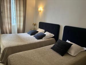 una camera con due letti con cuscini sopra di Hotel U Campanile a Vivario