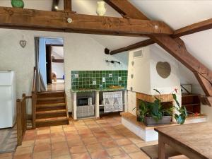a room with a kitchen with a fireplace and a staircase at Sous le bon Toit in Belley