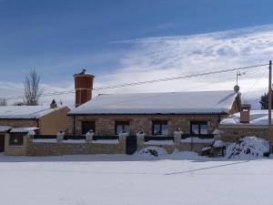 un edificio de ladrillo con techo cubierto de nieve en Casa Entre Hoces810paxJardín y barbacoa, en Fuentemizarra
