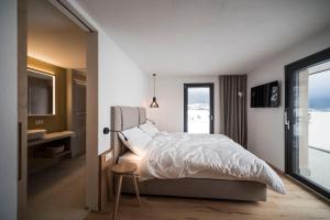 sypialnia z łóżkiem, biurkiem i oknem w obiekcie OVINA`s HAUS w mieście Sand in Taufers