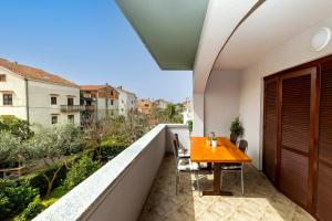 a balcony with a wooden table and chairs on a roof at Apartment Nea Zadar in Zadar