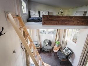 una casa pequeña con una escalera y un dormitorio en vakantiehuisje Tiny house met sauna in de bossen van de Veluwe, en Putten