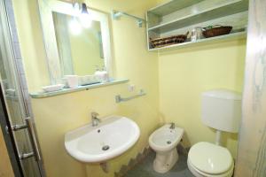 La salle de bains est pourvue d'un lavabo, de toilettes et d'un miroir. dans l'établissement Quadrilocale Tanca Manna, à Cannigione