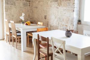 een eetkamer met witte tafels en stoelen bij Step to Kotor bay Guesthouse in Kotor