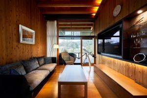 Sanso Amanosato في Katsuragi: غرفة معيشة مع أريكة وطاولة