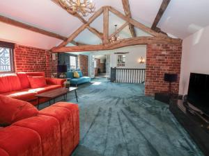a living room with a red couch and a brick wall at Lake View Barn in Macclesfield