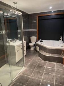 uma casa de banho com um chuveiro, uma banheira e um WC. em Blackstone Lakeside 4 Bedrooms 2 Bathrooms em Hadspen