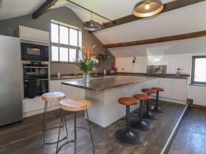 a kitchen with a large island with bar stools at Lake View Barn in Macclesfield