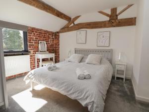 a bedroom with a bed with two towels on it at Lake View Barn in Macclesfield