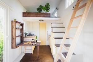 a tiny house with a desk and a loft at vakantiehuisje Tiny house met sauna in de bossen van de Veluwe in Putten