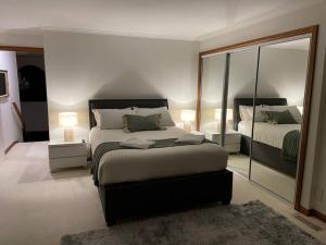 - une chambre avec 2 lits et un grand miroir dans l'établissement Blackstone Lakeside 4 Bedrooms 2 Bathrooms, à Hadspen
