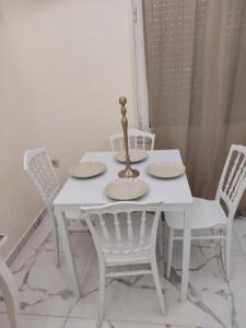 uma mesa de jantar branca com 4 cadeiras brancas em ATHENS City Center Historical Area em Atenas