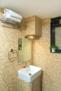 Hotel Orritel West في مومباي: حمام مع حوض ومرآة