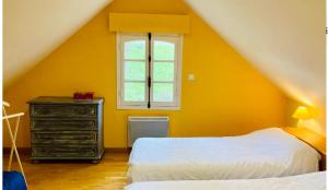 gelbes Zimmer mit einem Bett, einer Kommode und einem Fenster in der Unterkunft La Grange Dimière in Saint-Martin-Boulogne