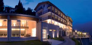 ein großes Gebäude in der Nacht mit eingeschaltetem Licht in der Unterkunft Belvedere Hotel in Crodo