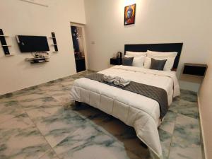 a bedroom with a large bed and a television at De luma Seaview in Pondicherry