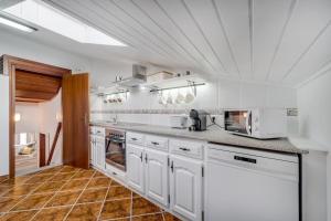 a large white kitchen with white cabinets and appliances at Casinha Da Igreja in Igrejinha
