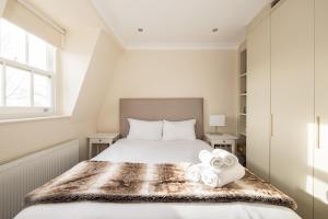 um quarto com uma cama com duas toalhas em Light-filled Chelsea Duplex em Londres