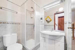 a bathroom with a toilet and a shower and a sink at Casinha Da Igreja in Igrejinha