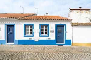 a blue and white house with blue doors at Casinha Da Igreja in Igrejinha